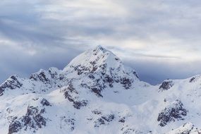 Landscape of the beautiful snowy mountain peak under cloudy sky