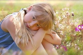 Little girl with long white hair amid the meadow