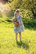 Little girl with a plush toy on the nature