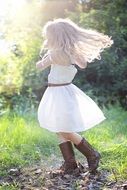 girl in a white dress and leather boots outdoor