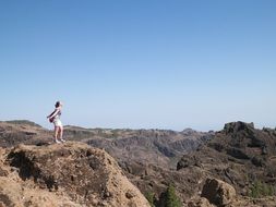 girl standing on a rock on a sunny day