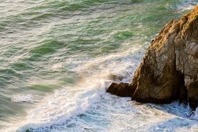ocean waves crashing on a rock