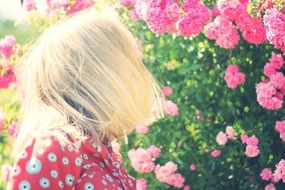 blonde on a background of pink blooming flowers