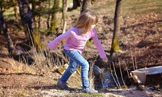 Little girl with long hair playing on nature