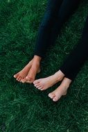Friends, two pair of feet on green grass