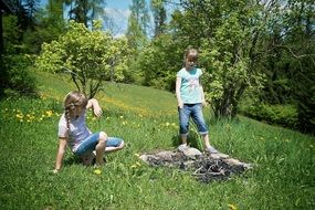 two child girls play on green grass