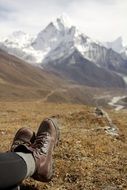 Shoes on the feet of a man sitting on a hill