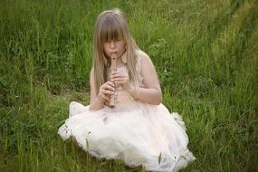 girl in white dress playing the flute in nature