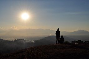 silhouettes of people in the mountains at sunset