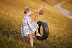 Little girl playing on the swing