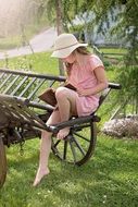 girl in the hat is reading a book