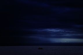 Beautiful waterscape with the boat under blue, cloudy sky