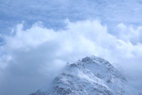 snowy mountain peak in the clouds