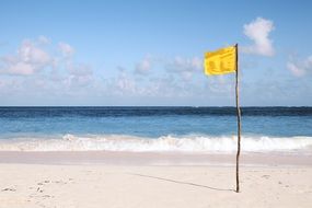yellow flag on an empty beach