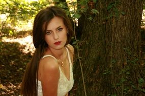 Portrait of a seductive girl with long hair on a background of forest nature