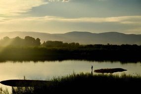 lake on a background of green meadows at sunrise