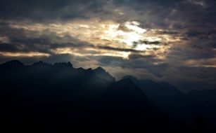 sunrise behind the clouds over the mountain