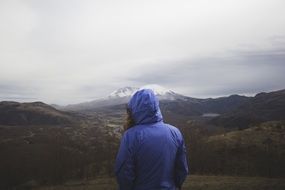 woman in hooded jacket in mountains