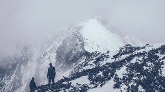 climbers at the peak of a snowy peak