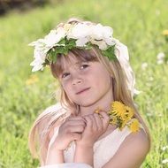 girl with a bouquet of dandelions in their hands