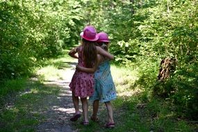 Girlfriends walk among green trees