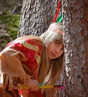 blond child girl&#039;s face among trees