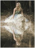 photo of A girl sits on a lake in the forest