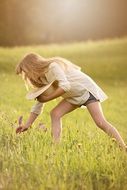 girl picking flowers on a summer meadow