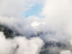 fluffy clouds in high mountains