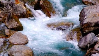 blue foamy stream on brown stones