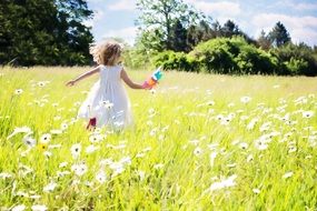 girl running on the field of daisies