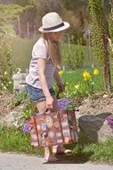 blonde girl with suitcase in hat