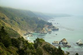 green rocky hills near the ocean