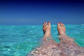 Girl's legs in the water in the Maldives