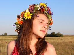 portrait of young girl with long hair in a wreath of flowers