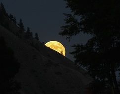 full moon behind of the mountain