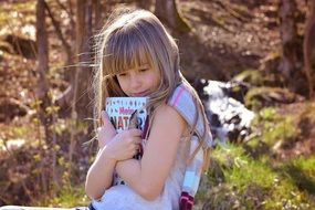 Little girl with long blond hair and a book