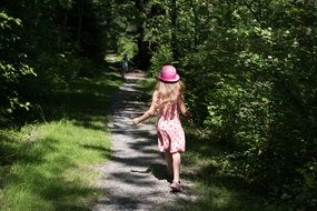 cute girl in pink hat runing away