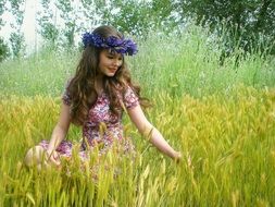 girl with a purple wreath on her head in the field