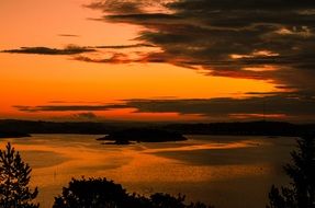 View with the beautiful and colorful sunset above the water and plants in Sweden