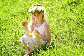 long hair blond girl child playing with flowers