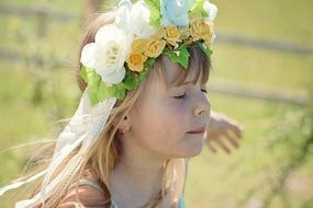 Little girl in wreath with eyes closed