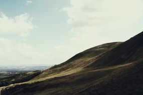 hills with green grass against a blue sky