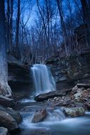 landscape of blue waterfall in the thicket of the forest at dusk