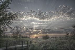 dramatic sunset landscape over a rural field