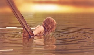 Little girl with long hair in the lake