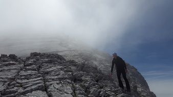 Climber on a rock in the fog in Berchtesgaden