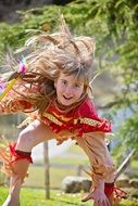 Little girl in an Indian costume playing in the nature