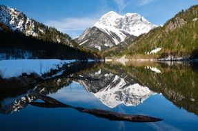 scenic winter mountain landscape reflected on water, austria