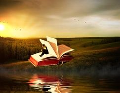 man is sitting on an open book on the background of the countryside